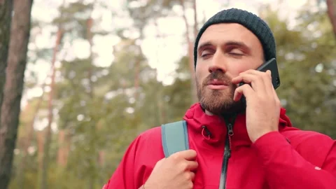 Close up of young caucasian bearded man talking on cell phone while standing in Stock Footage 147068251