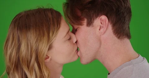 Close up of young Caucasian couple kissing on green screen Stock Footage