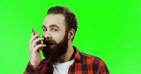Close up of the young caucasian man with a beard talking on the phone and then Stock Footage 90370580