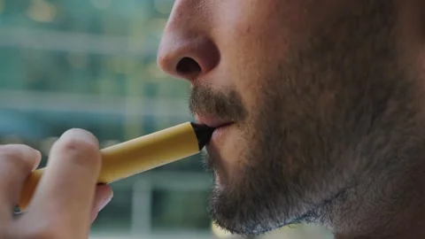 Close-up of young caucasian man with beard smoking an electronic cigarette Stock Footage 252267799