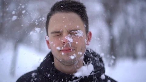 Close up of young caucasian man gets snowball on face during playing snowballs Stock Footage 111765048