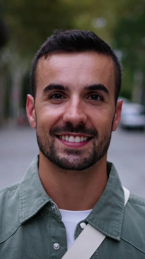 Close up young Caucasian smiling man walking looks nodding at camera on street Stock Footage 277121763