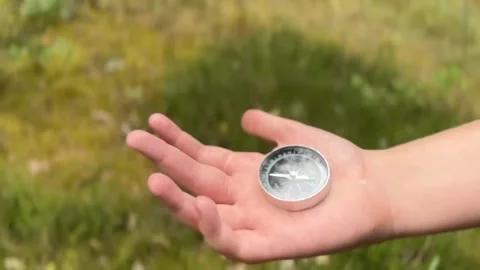 Close up a young child holds compass in his hands while in the forest Stock Footage 282311207