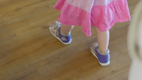 A close-up of a young child walking indoors, focusing on their small feet i.. Stock Footage 282979436
