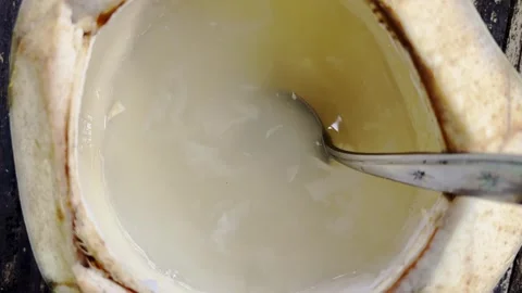 Close-up of young coconut water and soft flesh with spoon Stock Footage 346742796