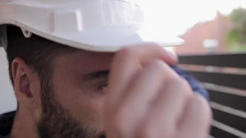 Close Up of young construction worker putting on hard hat in morning before work Stock Footage 240394268
