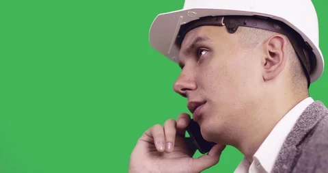 Close-up of a young construction worker in a white helmet talking on a mobile ph Vídeo Stock 86231836