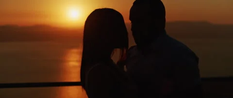Close up of a young couple embracing at sunset, spending a romantic evening t Stock Footage 136246547