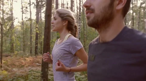 Close-up of young couple jogging together in the forest Stock-Footage 68056245