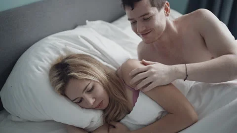 Close-up young couple lying in bed and having problems in sexual relations. Girl Stock Footage 141821219