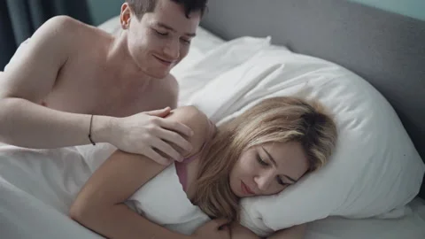 Close-up young couple lying in bed and having problems in sexual relations. Girl Stock Footage 144312465