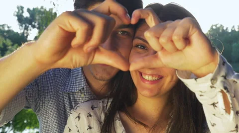 Close-up of young couple making a heart shape at sunset Stock Footage 64861016