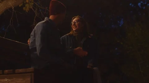 Close up of young couple sits on bentch in night park Stock-Footage 143645906