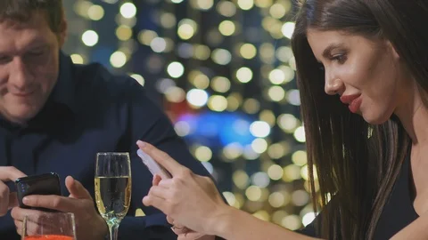 Close-up young couple sits at dinner table and surfs social websites 스톡 동영상 126133339