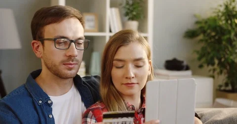 Close up of the young couple sitting close to each other, woman buying online on Stock Footage 83795477