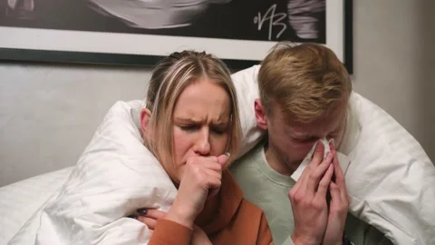 Close up young Couple sitting on sofa with high fever and flu at home. Man has a Stock Footage 146603395