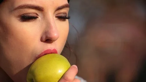 Close-up young cute woman eats green apple. Spring beriberi, vitamins in fruits Stock Footage 102516499