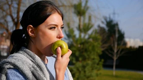 Close-up young cute woman eats green apple. Spring beriberi, vitamins in fruits Stock Footage 102516587
