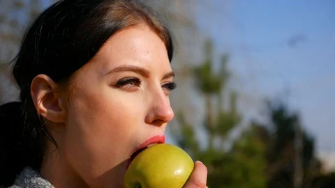 Close-up young cute woman eats green apple. Spring beriberi, vitamins in fruits Stock Footage 102516592