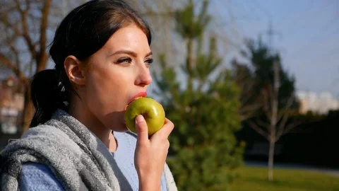 Close-up young cute woman eats green apple. Spring beriberi, vitamins in fruits Stock Footage 102516606