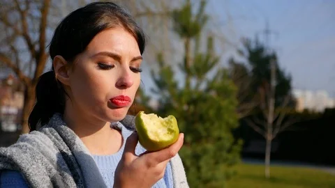 Close-up young cute woman eats green apple. Spring beriberi, vitamins in fruits Stock Footage 102516626