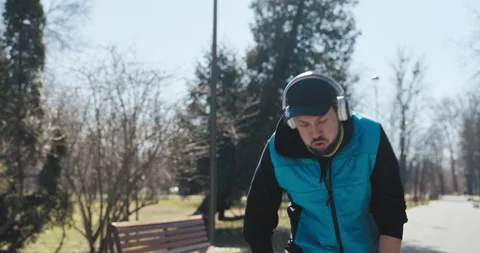 Close-up of young dad running in the park in the morning before work. He is Vídeo Stock 215801608