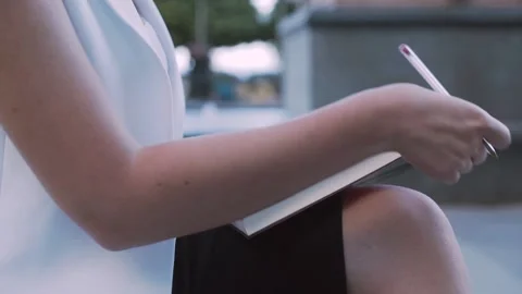 Close-up of young entrepreneur writing notes in diary during work break Stock Footage 132037851