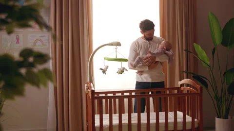 Close up young father gently hugs kiss a newborn baby in his arms. Playing Stock Footage 220266124