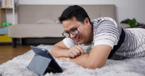 Close up, Young father lying down on carpet in the living room 스톡 동영상 201127571