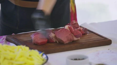 Close-Up of Young Female Chef Slicing Raw Meat for Pilaf on Cutting Board Stock Footage 346586860