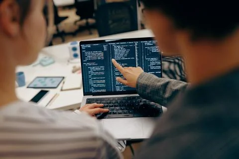 Close up of young female computer programmers is coding at laptops while sitting 写真素材