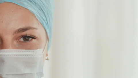 Close-up of young female doctor with a mask on face Stock Footage