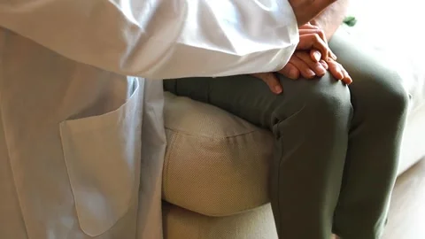 Close-up of a young female doctor's hands while holding the hands of an elderly Stock Footage 280011818