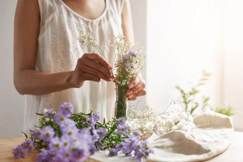 Close up of young female florist making tender bouquet at workplace. Copy space Foto stock