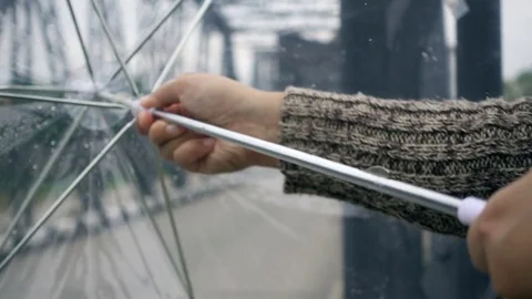Close-up of young female hand opens umbrella in raining day, slow motion shot Stockbeeldmateriaal 76328842