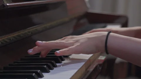 Close up of young female hands playing piano, shot in slow motion Stock Footage 299547335