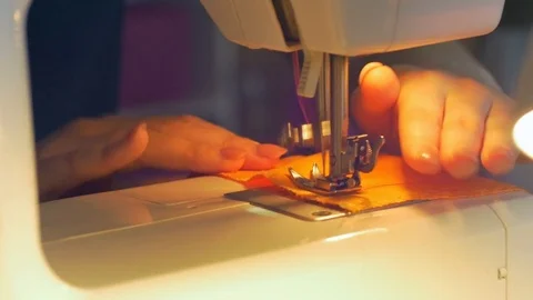 Close-up of young female tailor hands stitching fabric using a sewing machine. 動画素材 80471852
