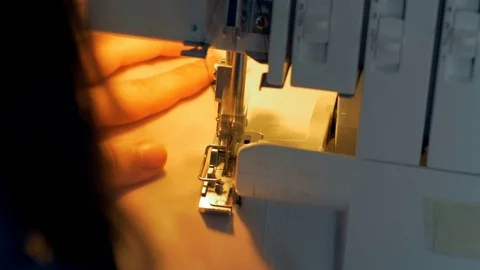 Close-up of young female tailor hands stitching fabric using a sewing machine. Stock Footage 80471880