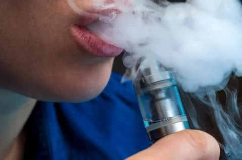 Close-up - young female vaping e-cigarette Stock Photos