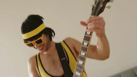 Close up of young funny hipster guy at home dressed in a vintage tight yellow Stock Footage 168107431