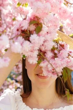 Close up. Young Gilrs Face Covered by Blooming Sakura Standing in the Parkl Stock Photos
