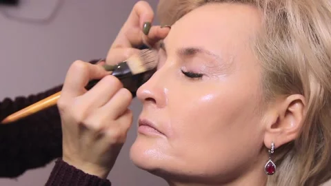 Close-up of a young girl doing makeup. The makeup artist applies the foundation  스톡 동영상 137570513