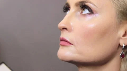Close-up of a young girl doing makeup. The makeup artist applies the foundation  스톡 동영상 137571111