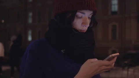 Close up of young girl dressed in jacket and knitted scarf using smartphone Stock Footage 83079494