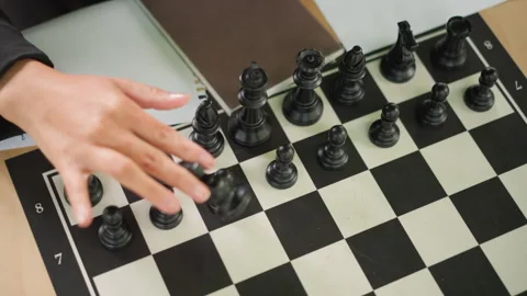 Close up of young girl playing chess moving black pieces on checkered board with Stock-Footage 346649480