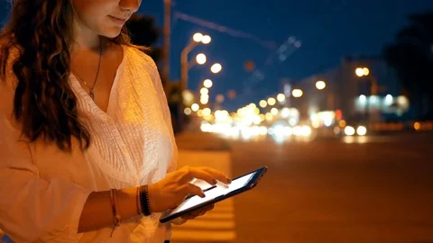 Close-up of young girl using tablet pc on the night city background. Stock Footage 76984489