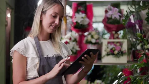 Close up of a young girl using a tablet while working in a flower shop Stock Footage 201866280