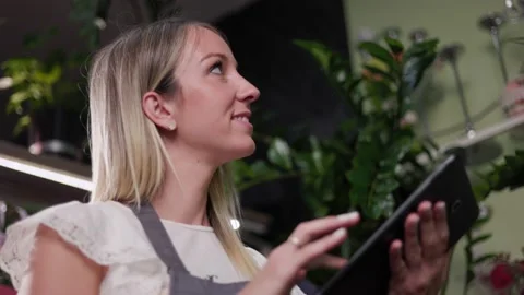 Close up of a young girl using a tablet while working in a flower shop Stock Footage 201870582