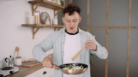 Close up of Young Good looking Man Cooking Happily in the Kitchen. Amateur Male Video stock 136587433