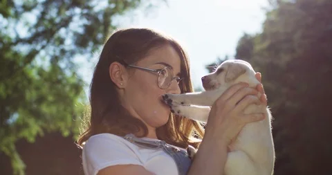 Close up of the young good looking smiled caucasian woman coddling her lovely Stock Footage 98101917